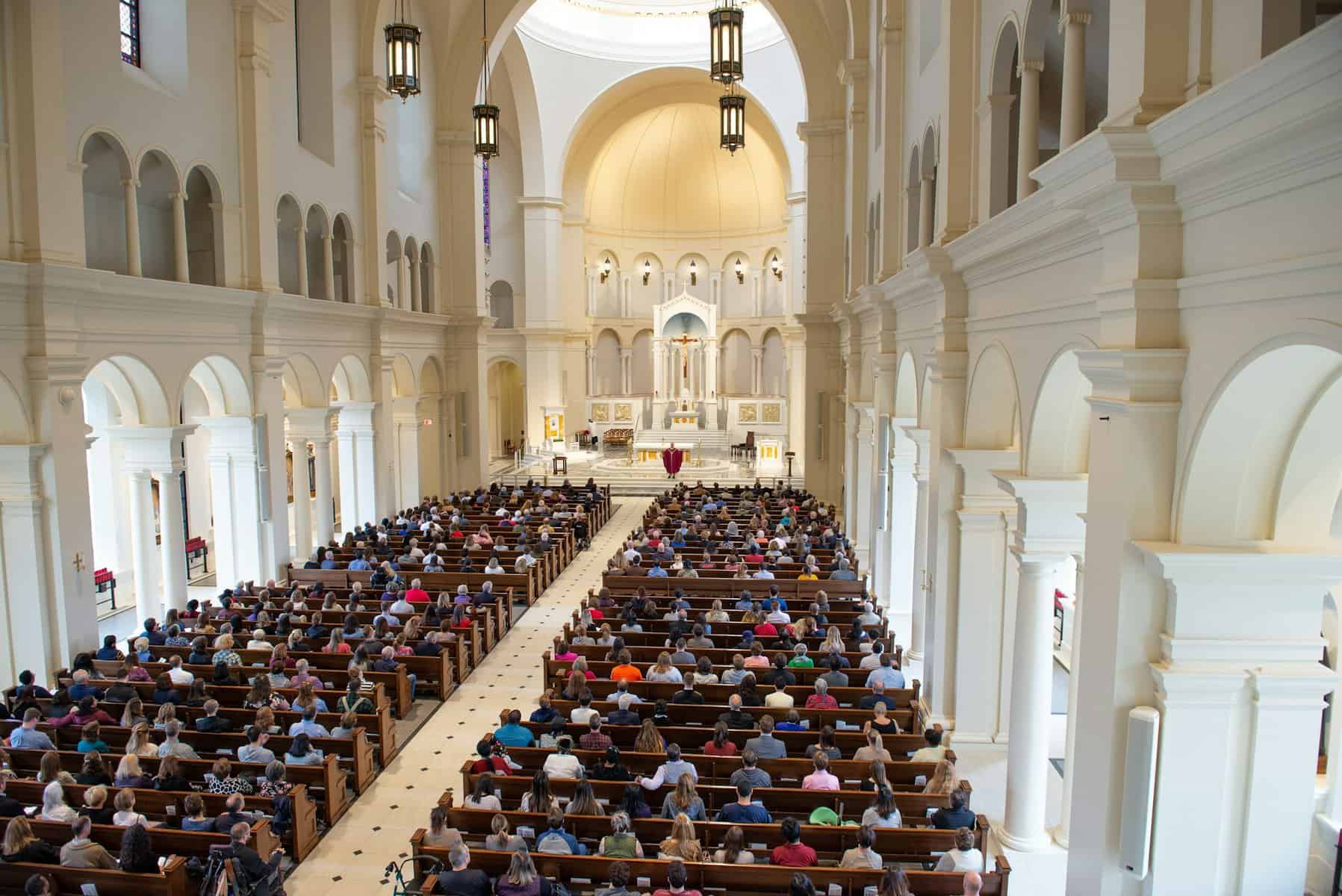 A Catholic mass in a large cathedral as ween from above.