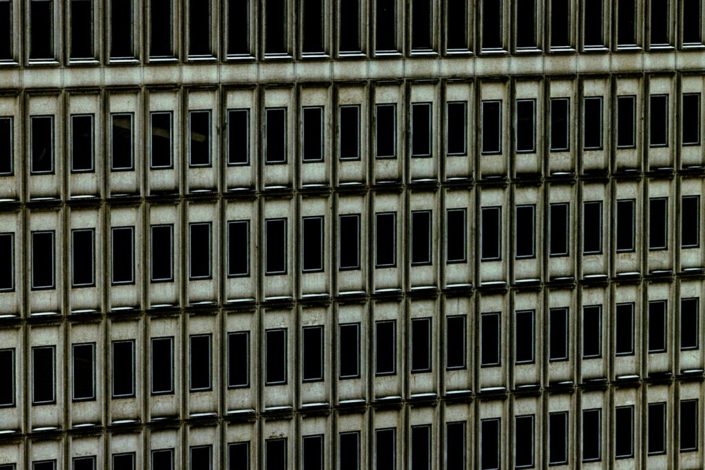 A concrete building's facade with rows of windows.