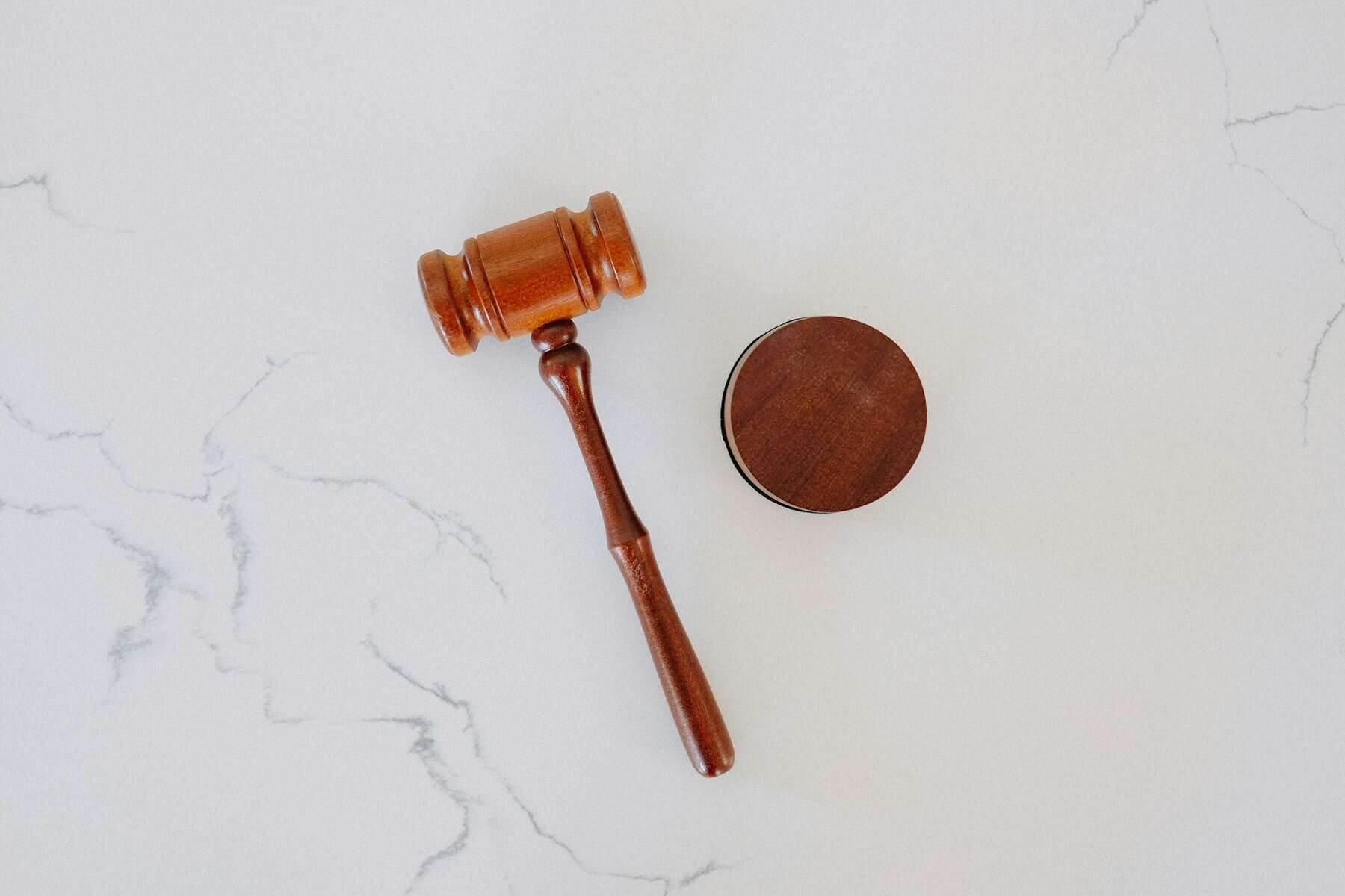 A dark wooden gavel on a marble table top.