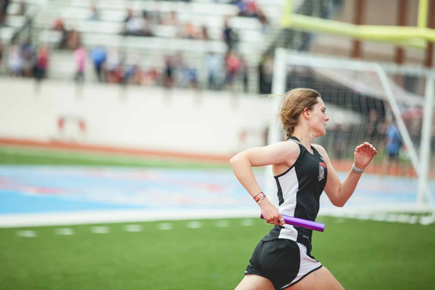 A female runner carrying a relay baton