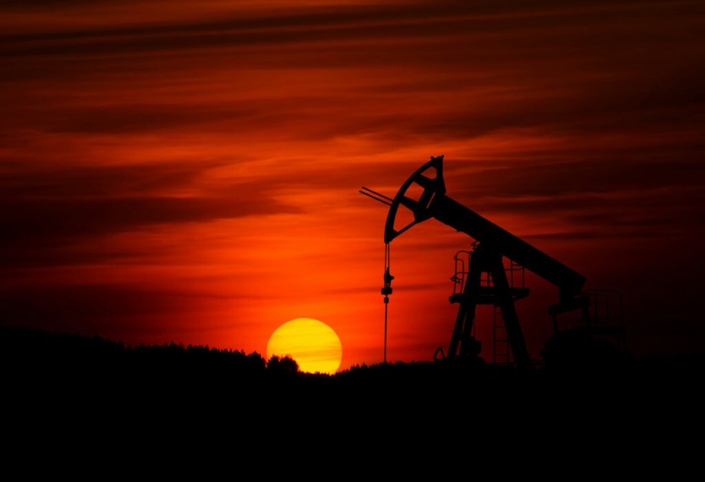 A pump-jack pumping crude oil at sunset.