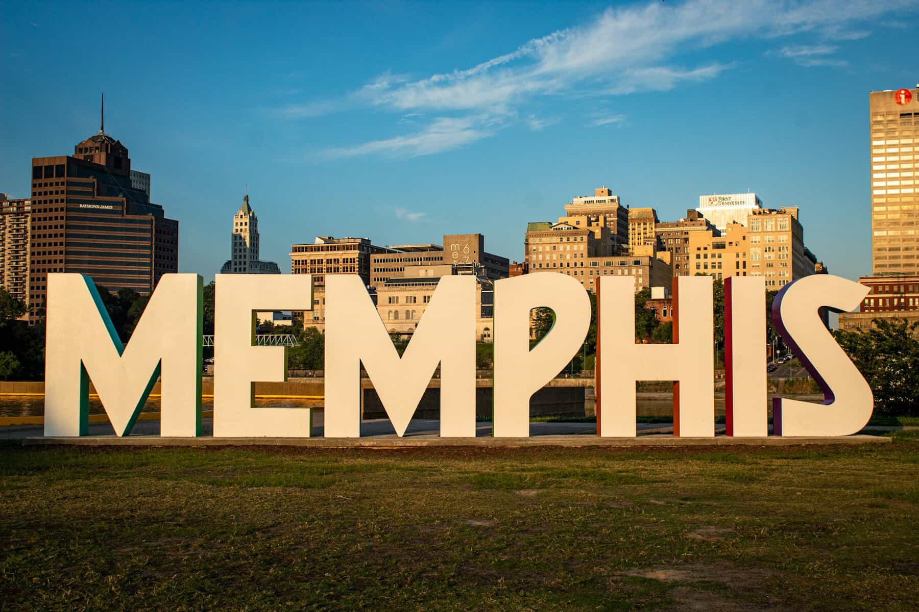 Huge white letters spell Memphis with the city behind them.