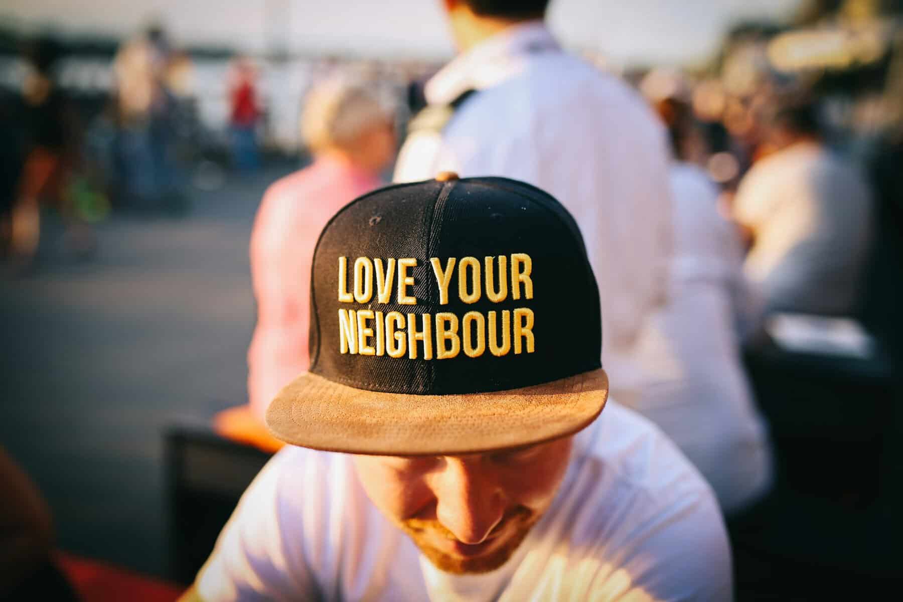 A man wearing a love your neighbour hat.
