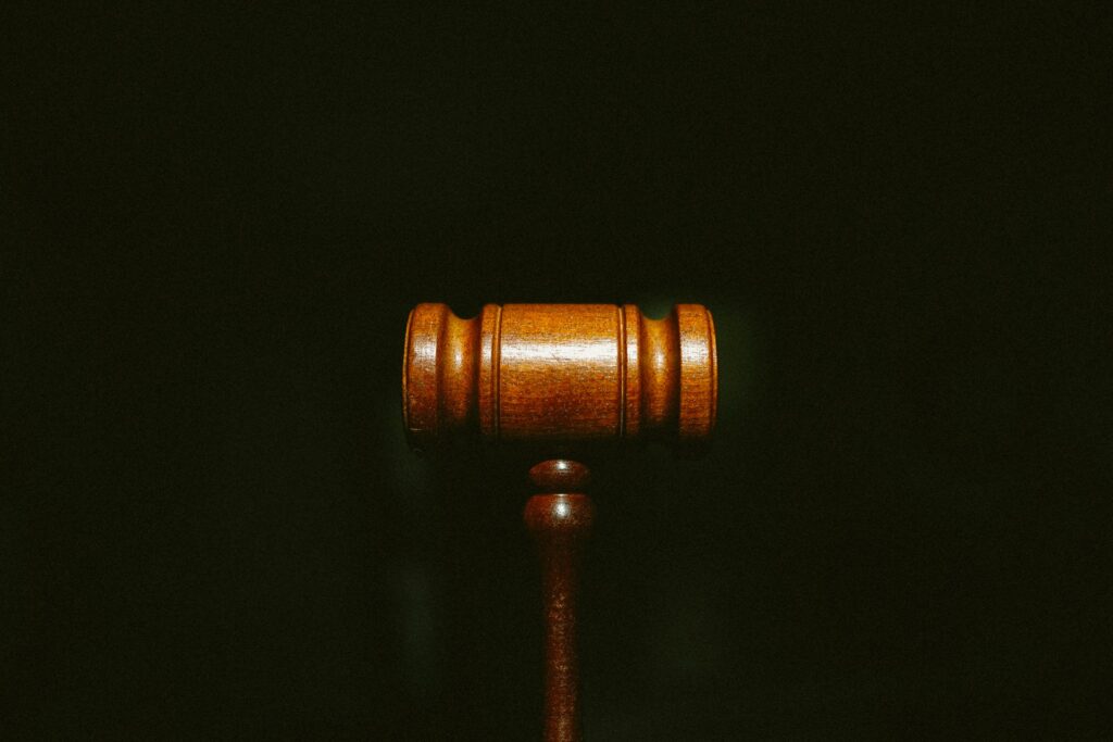 The head of a judges gavel against a black background.