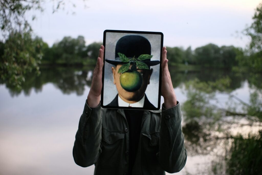 A person holding a depiction of a face in front of their face on a tablet.