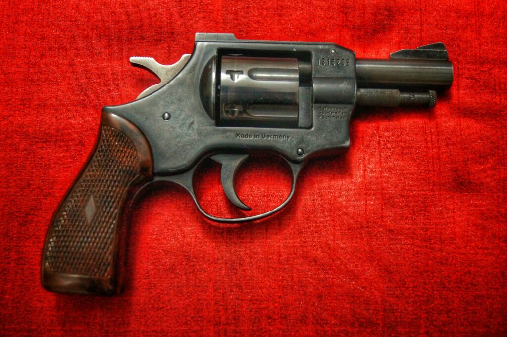 Public Executions Return to the National Debate An old revolver rests on a red fabric.