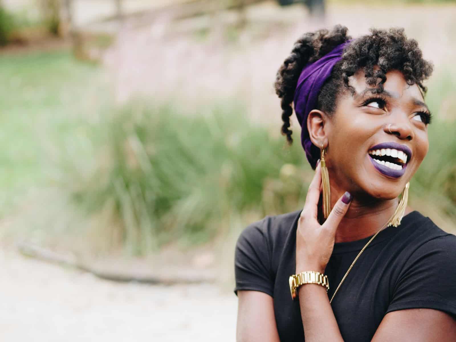 A beautiful Black woman looks to the side away from the camera.