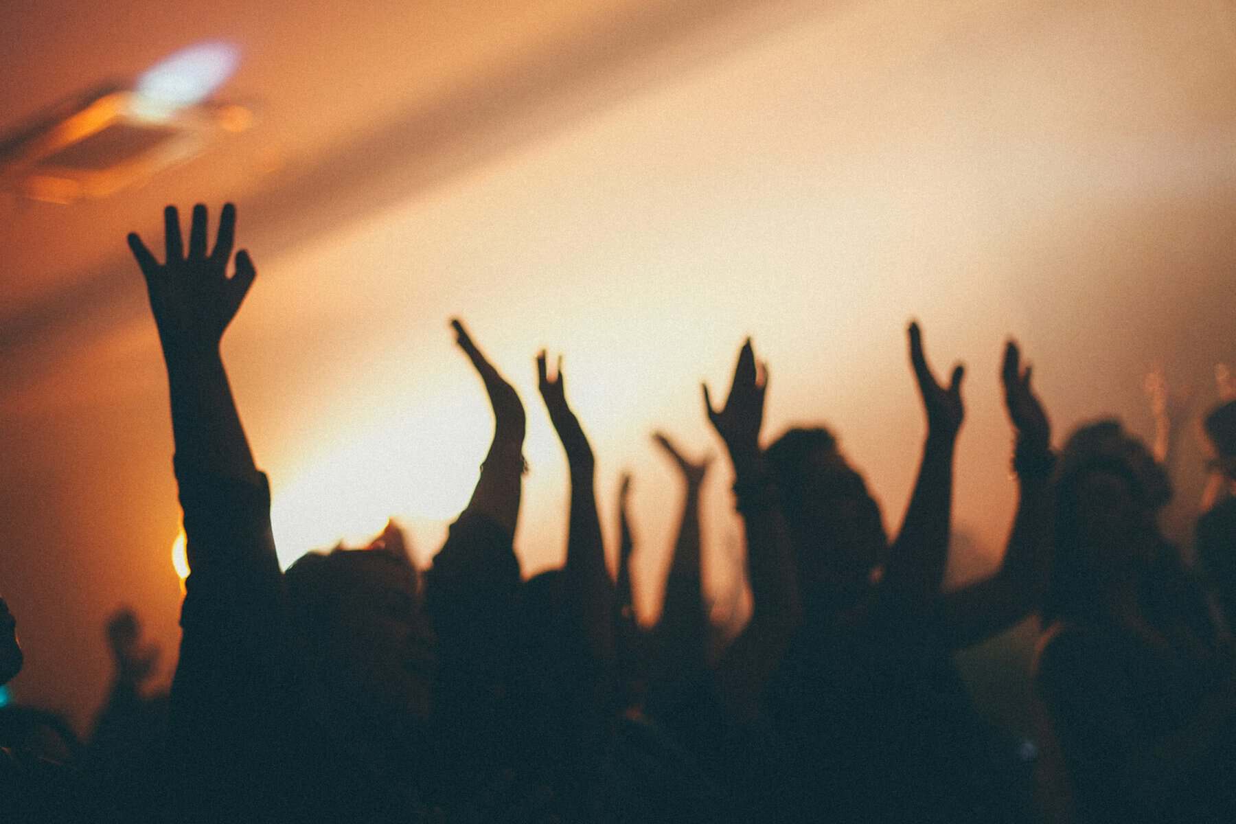 People at a concert with hands raised.
