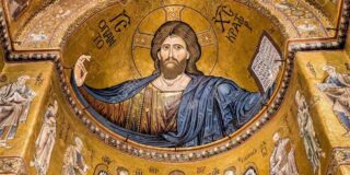 A mosaic of Christ in a blue robe with his arms outstretched