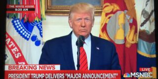 A screen shot from MSNBC shows former President Trump at a microphone.