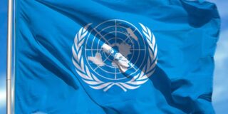 The UN flag is seen waving in a breeze.