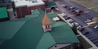 The green roof of rock springs church megachurch is seen from above.