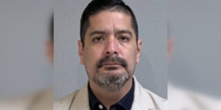 Gerardo Gonzalez is shown unsmiling and looking forward in a tan striped seersucker suit jacket and black dress shirt.