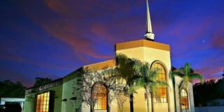 The church building of Pentecostals of Deland is shown during blue hour with pink clouds.