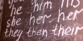 A chalk board with pronouns written on it.